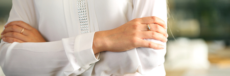 Letterbox view of arms of woman wearing formal clothes in office crossed on chest closeupの写真素材