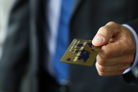 Man in suit and tie offering banking card to pay for service close-upの写真素材