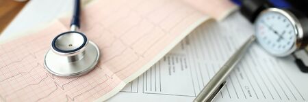 Letterbox view of empty GP office with stethoscope head lying at cardiogram paper closeupの写真素材