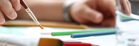 Letterbox view of male hand making drawing with watercolor brush closeupの写真素材