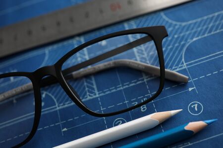 Blueprint lying at worktable with drawing tools on it close-up