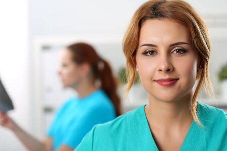 Close-up of beautiful confident medical worker in special uniform. Modern medicine and innovation. Healthcare and check-up concept. Nurse on background