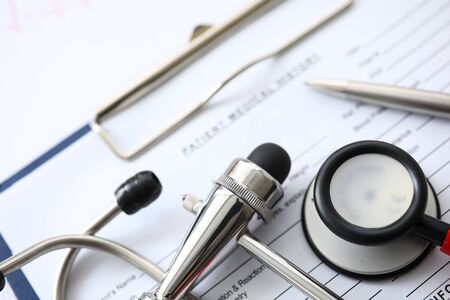 Medical instruments lying at patient history list close-up
