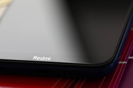 Barcelona, Spain - February 10, 2020: Xiaomi redmi logo at modern smartphone screen lying at colorful fantail close-upのeditorial素材