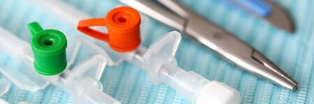 Close-up of sterile medical equipments and instruments for operation. Collection of steel tools on blue material. Plastic tubes. Healthcare and ambulance conceptの写真素材
