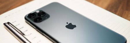 Minsk, Belarus - December 11, 2019: iPhone pro device lying at opened notebook with silver pen close-upのeditorial素材