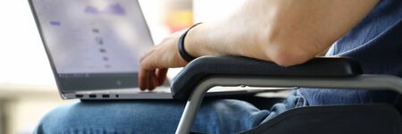 Man sitting in wheelchair working with laptop computer concept