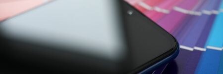 Screen of modern smartphone lying at colorful fantail close-up