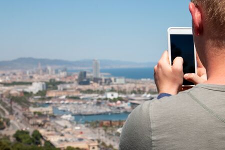 Male hands holding smartphone trying to take travel photo close-up