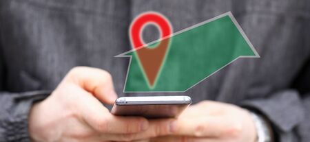 Man holding in hands smartphone while using navigation software to find way close-up