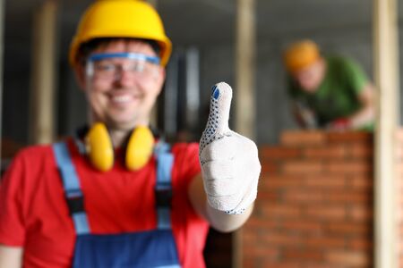 Happy smiling male worker showing thumb up gesture close-up. Fine house renovation or best...