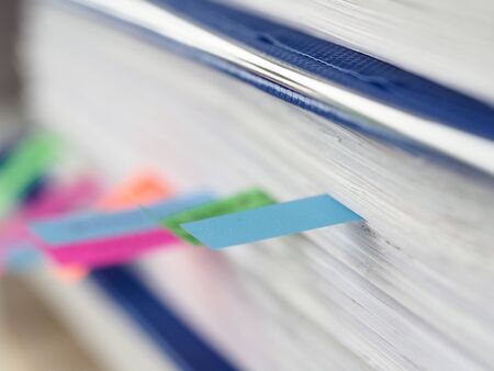 Close up color stickers between documents folder. Stickers, blocks paper for notes and bookmarks. Mark folders in archive storage. Document archiving systems. Paperwork sticky bookmarksの写真素材