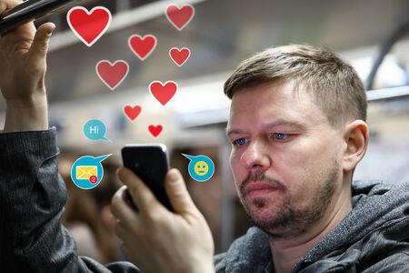Handsome man in subway using dating apps portraitの写真素材