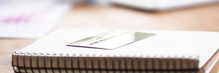 Table in bank notepad with spring and credit card. Transfer cash to bank account. Analysis expenses and income by credit card. Administrative work. Overdraft debit card. Making transfersの写真素材