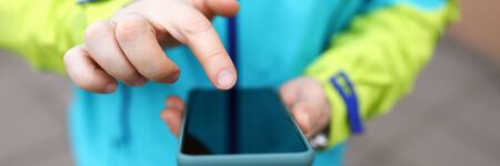 Close-up man in jacket clicks touch screen phone. Satisfaction communicative needs. Communication...
