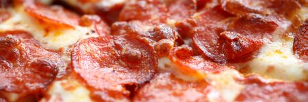 Fresh baked pizza with crusty cheese and hot tasty pepperoni ready to eat close-upの写真素材