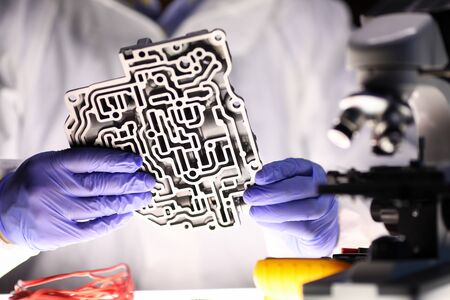 Man holds metal part from automatic transmission. Transmission service repair center master...