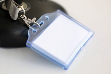 On table is plastic badge plaque, an empty badge. Participation as speaker or presenter at symposia and conferences. Uniform element designed to provide information about its carrierの写真素材