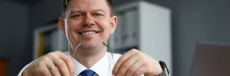 Man business clothes sitting at table and smiling. Happy man working at home in self-isolation. Implementation methods to strengthen financial system enterprise during economic crisisの写真素材