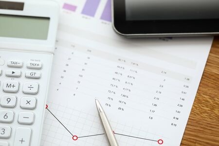 Close-up of business papers laying on working table in office. Analysis with diagrams and numbers....