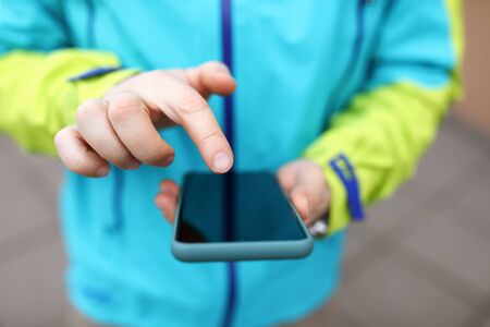 Close-up man in jacket clicks touch screen phone. Satisfaction communicative needs. Communication...