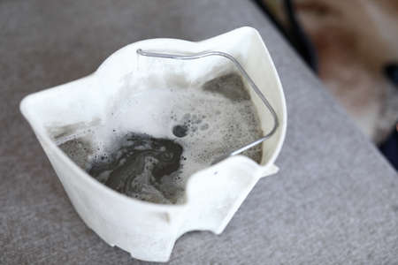 Plastic vacuum cleaner tank full of dirty water standing on couch showing room contamination level...