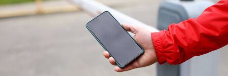 Male hand holding smartphone switching limit bar to yard passage close-up