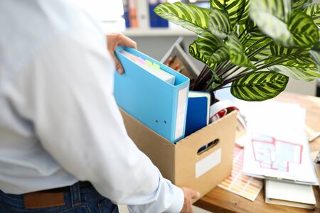 Businessman got fired during covid economy recession and taking his property out from office close-upの写真素材