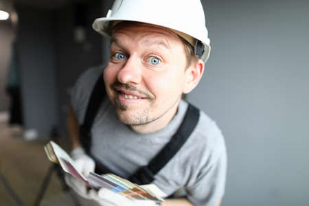 Close-up of cheerful male worker looking curious and posing on camera. Professional construction...