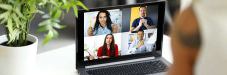 Woman talking with international colleagues using online video chat service at workplace closeup
