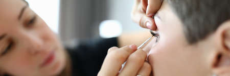 Close-up of visagist using professional cosmetics. Make-up artist doing makeup to woman. Visagiste making visage to businesswoman. Beauty and maquillage conceptの写真素材