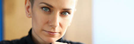 Close-up of lovely woman looking at camera with calmness and seriousness. Serious female person...