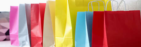 There are colorful bags on couch after shopping. Sales and discounts in online stores conceptの写真素材