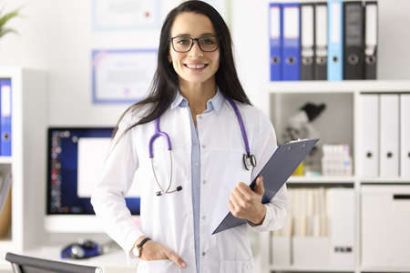 Portrait of smiling female doctor in white coat in medical office. Medical centers concept