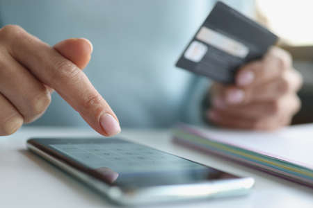 Woman makes online payments through smartphone. Online payment by bank cards conceptの写真素材