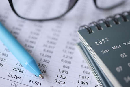 Ballpoint pen and calendars lying on documents with numbers close-up. Documentation in accounting conceptの写真素材