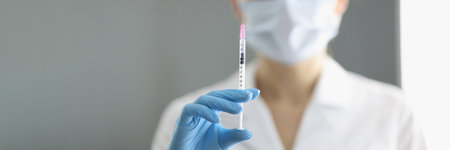 Portrait of doctor in whose hand medical syringe with needle. New vaccine development concept