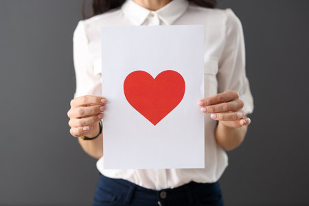 Woman holding red heart drawn on paper closeup. Valentines day cards conceptの写真素材