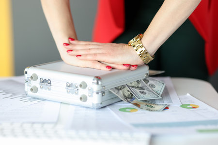 Female hands closing suitcase with money in office closeup. Doing business successfully concept