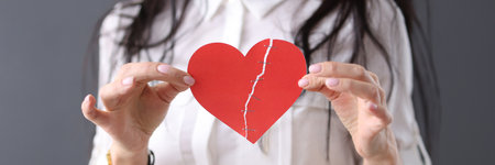 Woman holds glued heart in her hands. Love relationship concept