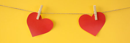 Two hearts weigh on ropes fastened with clothespins. Celebrating valentines day conceptの写真素材