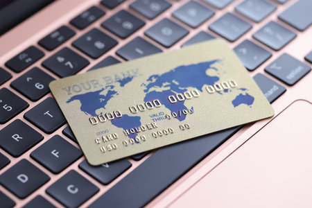 Credit bank card lying on laptop keyboard closeup. Online shopping concept