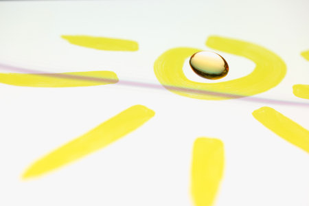 Vitamin D and E capsule lies inside drawn sun. The benefits of vitamins for the body conceptの写真素材