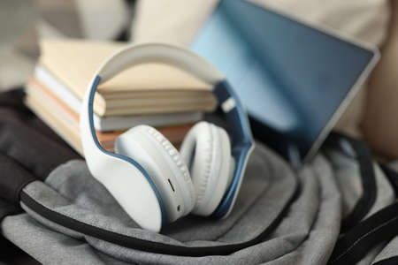 On backpack are headphones, a tablet and books. Remote work and travel conceptの写真素材