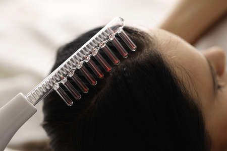 Woman is doing hair strengthening procedures. Restoration of hair follicles conceptの写真素材