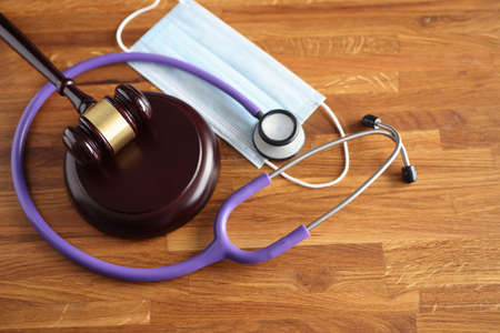 On table is a gavel for the judge stethoscope and medical mask. Medical litigation conceptの写真素材