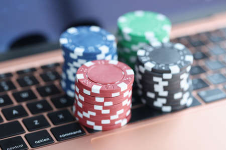 On laptop keyboard are colorful casino chips. Online gambling on the internet concept