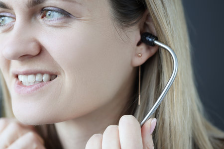 Doctor cardiologist inserting stethoscope into ears in clinic. Cardiology practice conceptの写真素材
