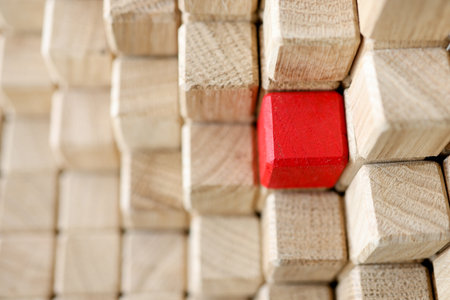 Pyramid of beige wooden cubes, one of them is red. Profitable commercial offer concept