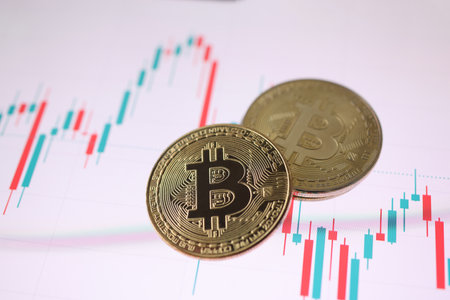 Gold bitcoin cryptocurrency coin lying on trading chart. Cryptocurrency exchange conceptの写真素材